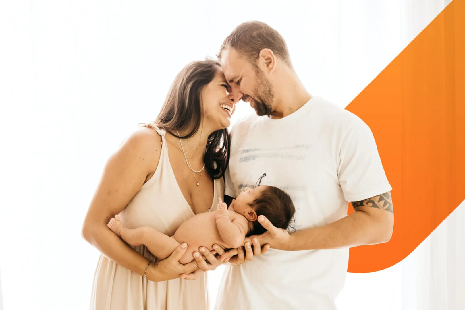 family-holding-newbord-baby-with-decorative-pill-in-background